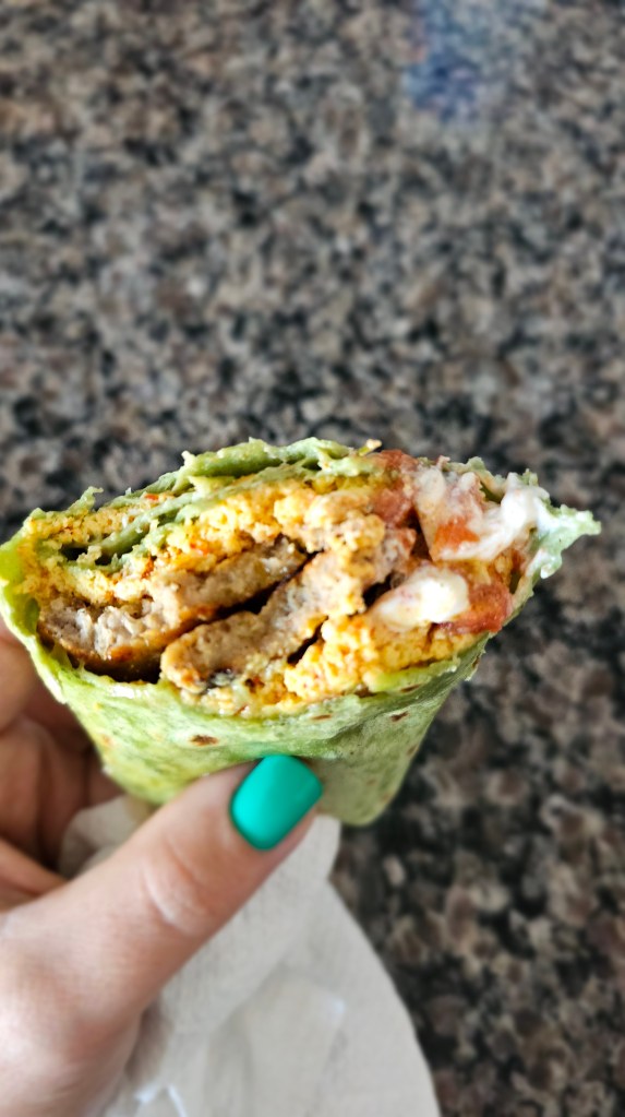 Close-up of high protein breakfast burrito in a spinach tortilla with egg and sausage