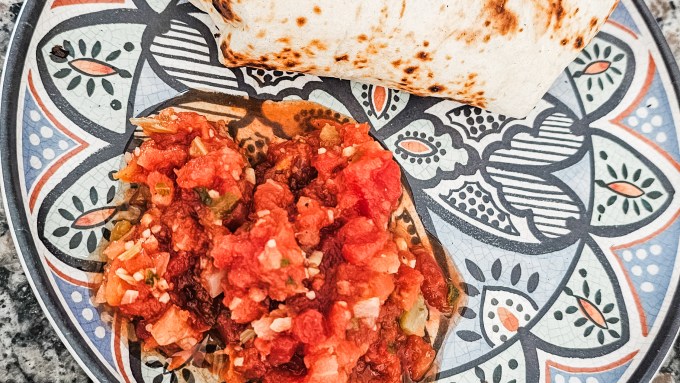 High protein breakfast burrito served with fresh salsa on a decorative plate