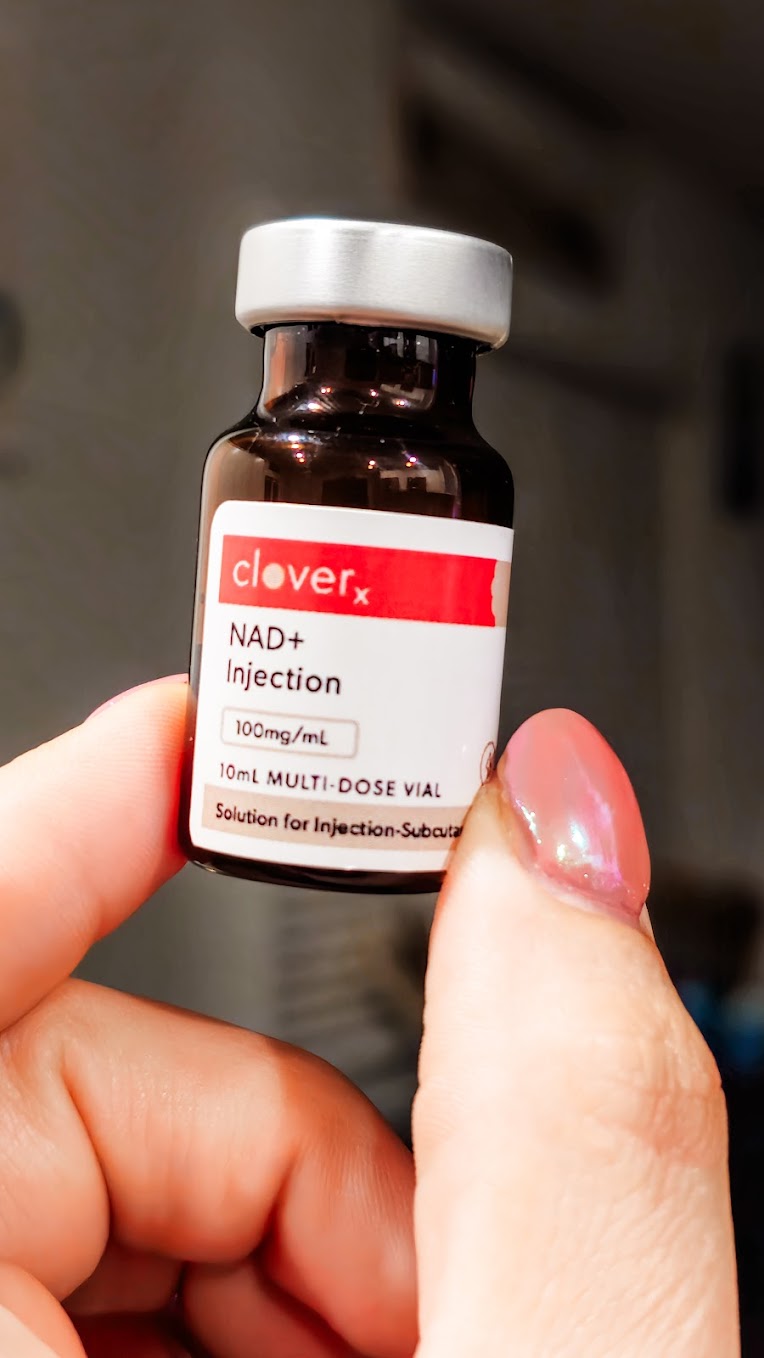 Hand holding a CloveRX NAD+ injection vial prescribed through EllieMD telehealth, 100mg/mL, 10mL multi-dose vial for subcutaneous use